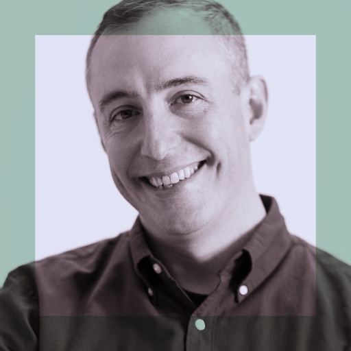A person with short hair, wearing a button-up shirt, smiles at the camera. The image has a muted color overlay with a transparent square in the center.
